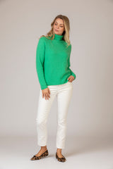 Bright Green Roll Neck Cashmere Jumper | Esthēme Cachemire at Sarah Thomson | Model on set with white cords