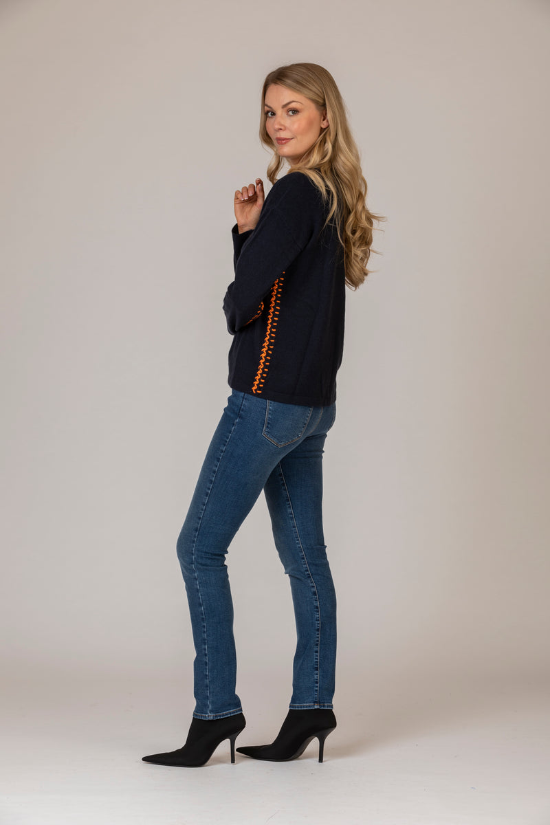 Cashmere V-Neck Jumper with Contrast Stitching in Navy and Orange | Estheme Cashmere at Sarah Thomson Melrose | Side profile with jeans