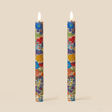 Two floral-patterned candles on a beige background