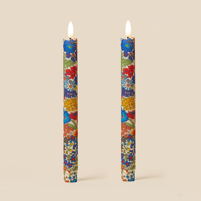 Two floral-patterned candles on a beige background